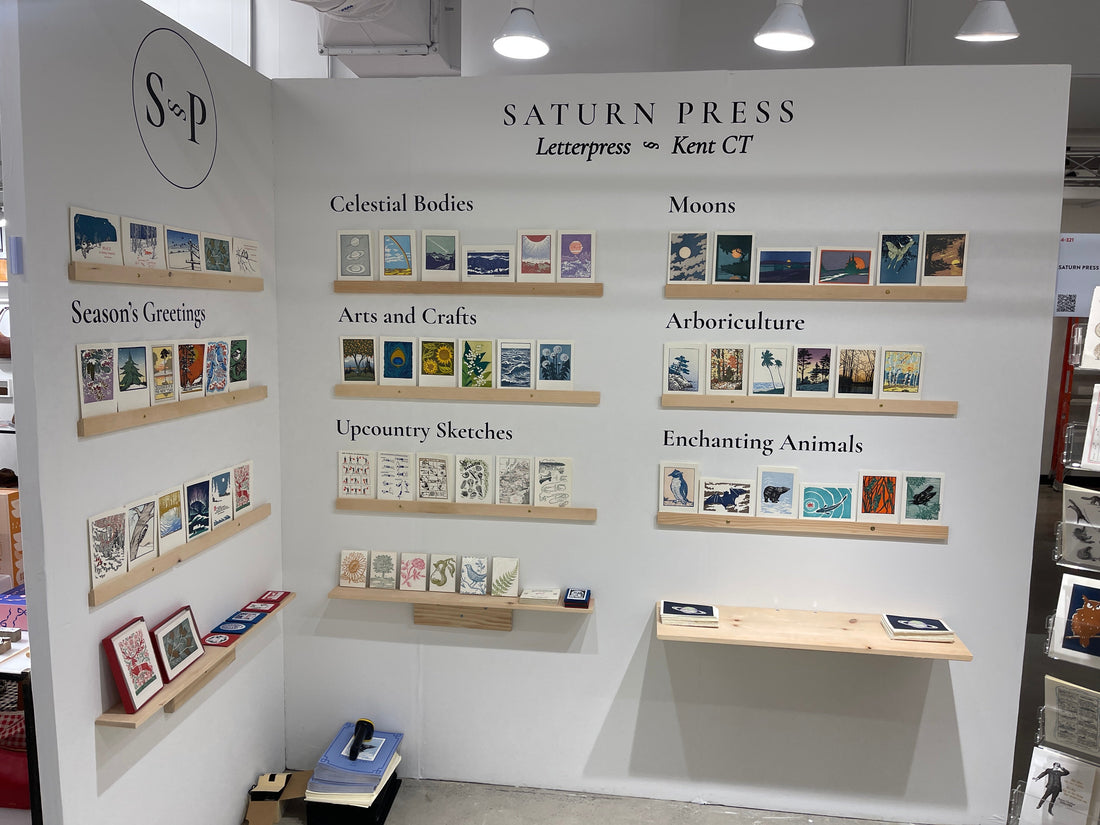 Image showing the Saturn Press booth at the Shoppe Object show highlighting exemplary cards from our core letterpress card collections.